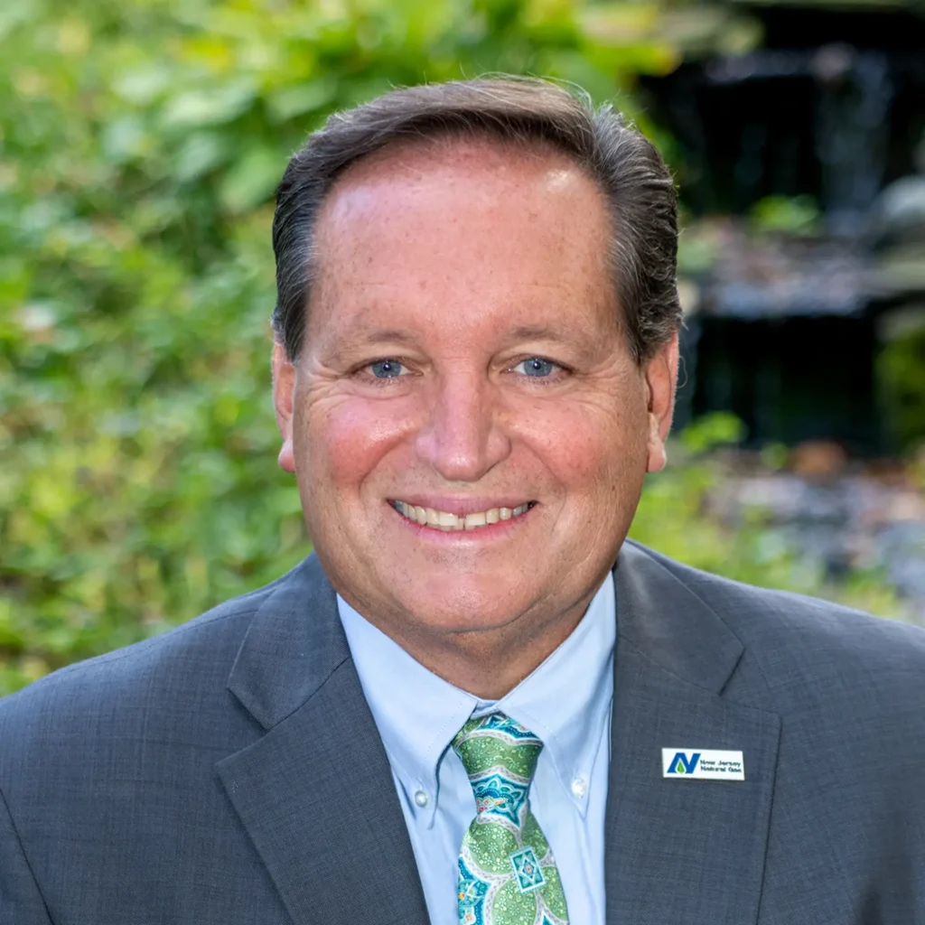 Professional headshot of a smiling man in a suit and tie.