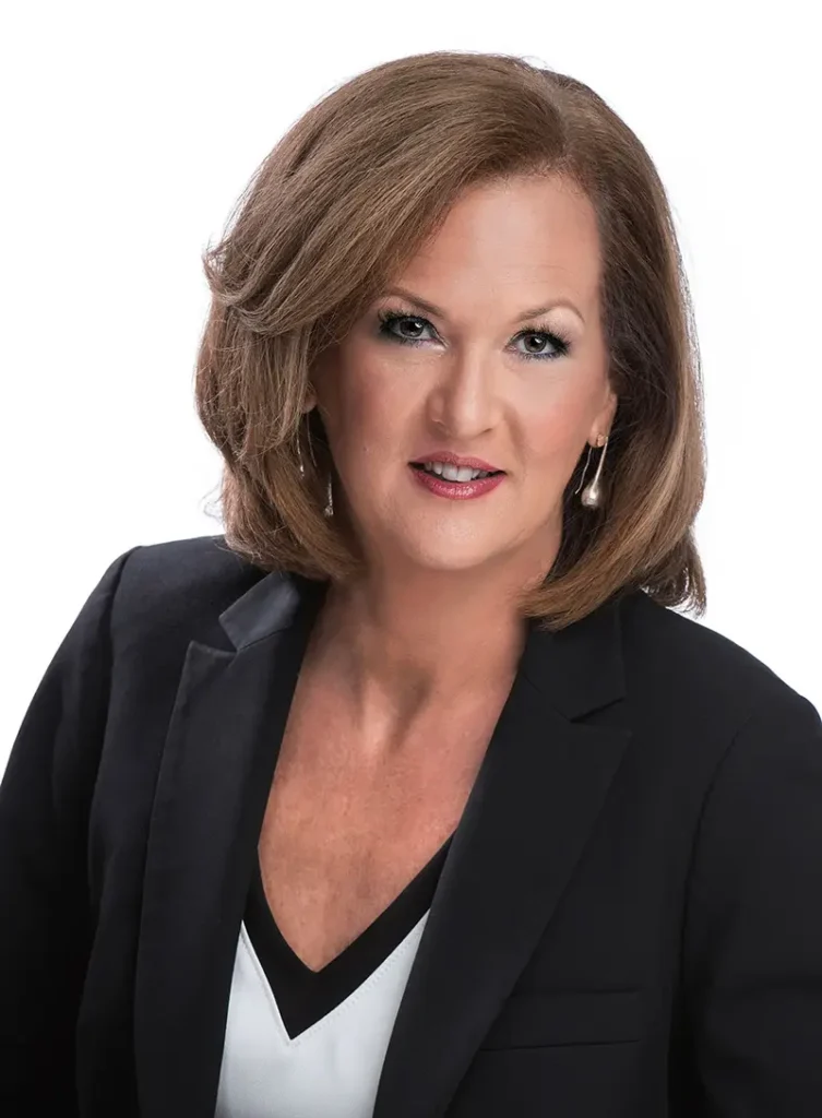 Professional headshot of a woman with brown hair wearing a black blazer.