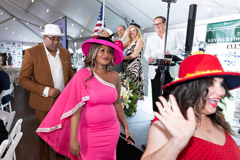 2 women and one man showing of their ornate party hats
