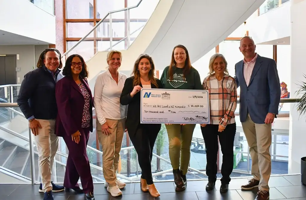 Group of people holding a large check for $10,000.