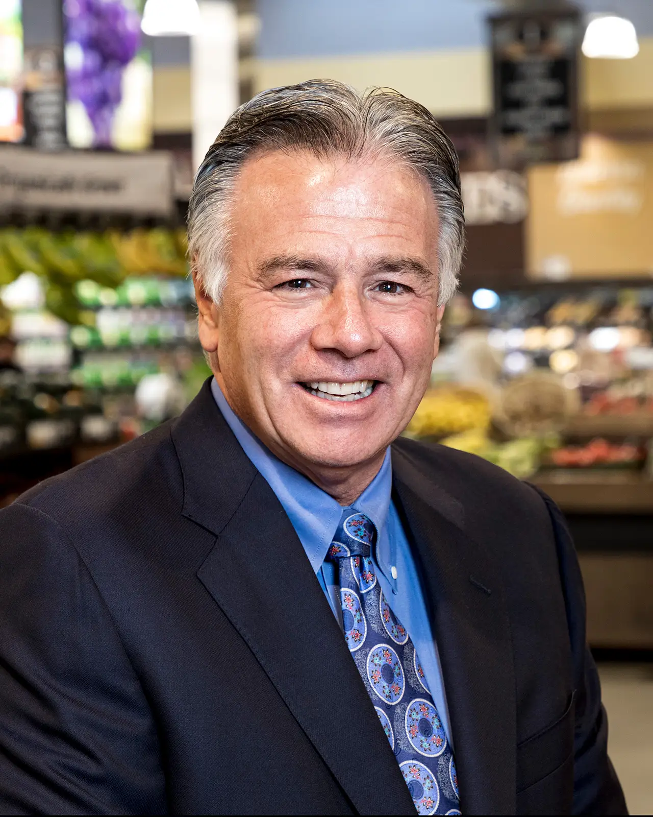 Smiling man in suit and tie, indoors.