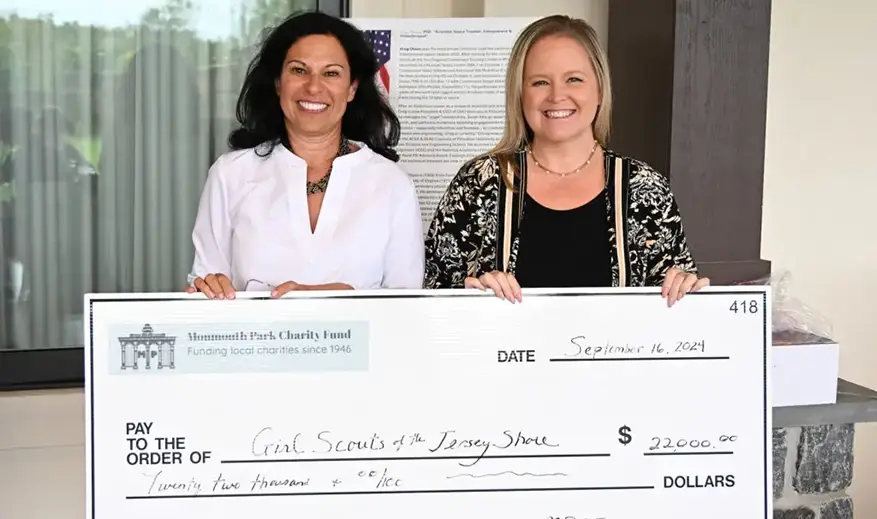 Two women hold a large check for $22,000 to Girl Scouts of the Jersey Shore.