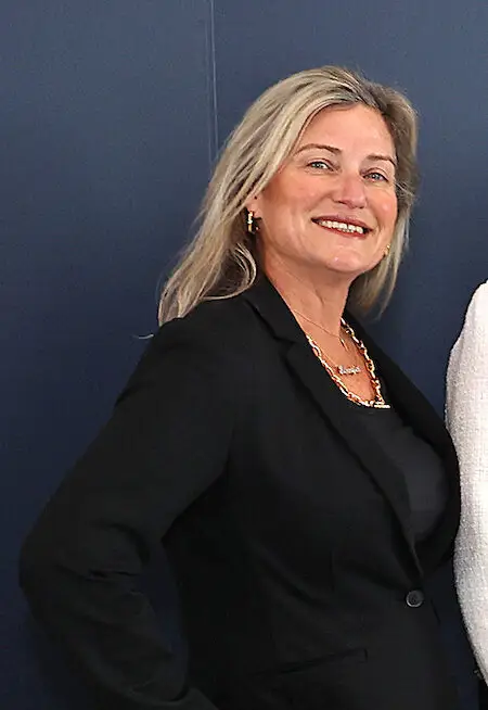 Blonde woman in a black blazer smiling